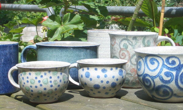 Tassen und Becher mit Spiral- und Streifenmuster im Garten